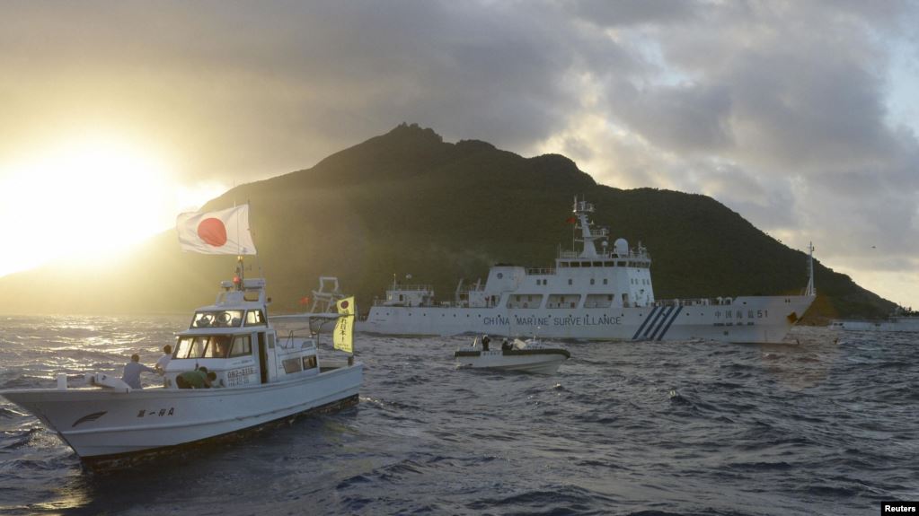中国海监船51号（中）在东中国海尖阁列岛附近航行，日本海岸警卫队的船只在旁（右），前船为日本渔船。（2013年7月1日）