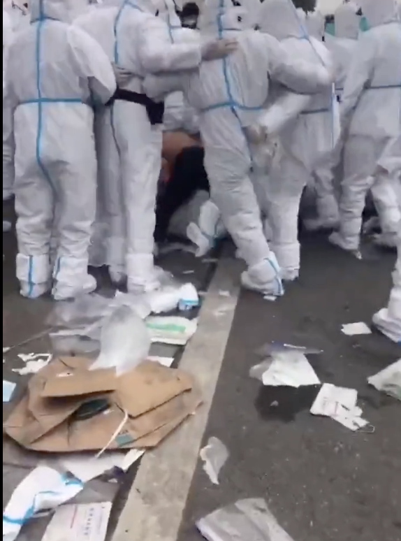社交媒体上疯传郑州富士康员工抗议影片，「大白」向一民众围踹。   图：翻摄自推特影片