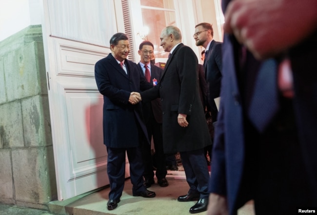 俄罗斯总统普京和中国领导人习近平出席招待会后走出克里姆林宫握手告别。（2023年3月21日）