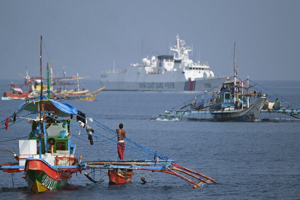 一艘中国海警船在斯卡伯勒浅滩附近跟踪菲律宾渔船，摄于今年9月。菲中两国都声称对南中国海的这片水域拥有主权。